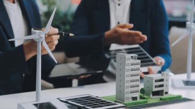 Çağdaş ofis ortamında çevre dostu yeni bir kompleks projesinde işbirliği yapan genç profesyonellerden oluşan bir ekip.