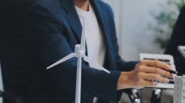 Çağdaş ofis ortamında çevre dostu yeni bir kompleks projesinde işbirliği yapan genç profesyonellerden oluşan bir ekip.
