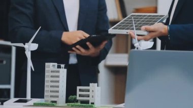 Çağdaş ofis ortamında çevre dostu yeni bir kompleks projesinde işbirliği yapan genç profesyonellerden oluşan bir ekip.