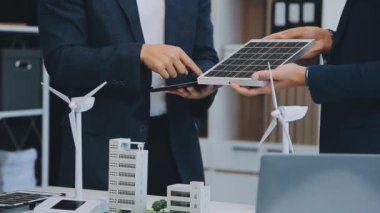 Çağdaş ofis ortamında çevre dostu yeni bir kompleks projesinde işbirliği yapan genç profesyonellerden oluşan bir ekip.