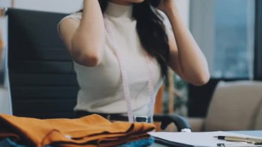 vlogger, blog yazarı küçük KOBİ iş kadını Asyalı güzel kadın kıyafetleri canlı yayın satışı internet üzerinden satışı, ana ofiste mevcut ürün detaylarını gösterme, girişimci ekommerce