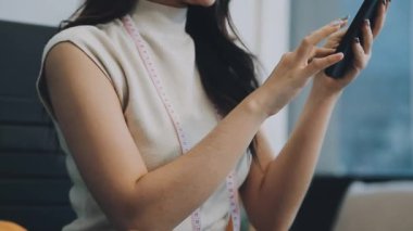vlogger, blog yazarı küçük KOBİ iş kadını Asyalı güzel kadın kıyafetleri canlı yayın satışı internet üzerinden satışı, ana ofiste mevcut ürün detaylarını gösterme, girişimci ekommerce