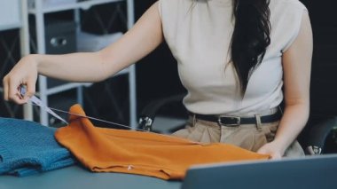 vlogger, blog yazarı küçük KOBİ iş kadını Asyalı güzel kadın kıyafetleri canlı yayın satışı internet üzerinden satışı, ana ofiste mevcut ürün detaylarını gösterme, girişimci ekommerce