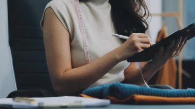 vlogger, blog yazarı küçük KOBİ iş kadını Asyalı güzel kadın kıyafetleri canlı yayın satışı internet üzerinden satışı, ana ofiste mevcut ürün detaylarını gösterme, girişimci ekommerce