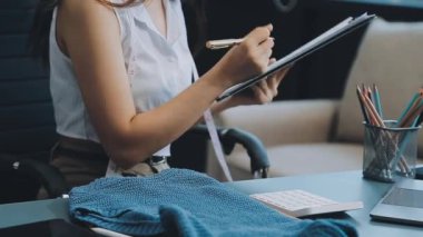 vlogger, blog yazarı küçük KOBİ iş kadını Asyalı güzel kadın elbise satıyor, ürün detaylarını ev ofisinde gösteriyor, girişimci ekommerce