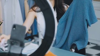 vlogger, blog yazarı küçük KOBİ iş kadını Asyalı güzel kadın elbise satıyor, ürün detaylarını ev ofisinde gösteriyor, girişimci ekommerce