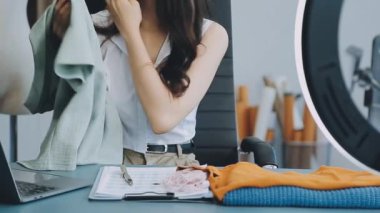 vlogger, blog yazarı küçük KOBİ iş kadını Asyalı güzel kadın elbise satıyor, ürün detaylarını ev ofisinde gösteriyor, girişimci ekommerce