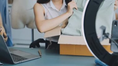 vlogger, blog yazarı küçük KOBİ iş kadını Asyalı güzel kadın elbise satıyor, ürün detaylarını ev ofisinde gösteriyor, girişimci ekommerce