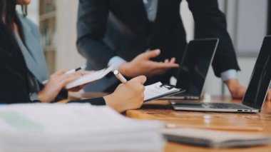 Bir grup sıradan giyinmiş Asyalı iş adamı ofiste fikirleri tartışıyor. Yaratıcı profesyoneller, yeni başarılı girişim projesinin önemli konularını tartışmak üzere toplantıda bir araya geldiler.