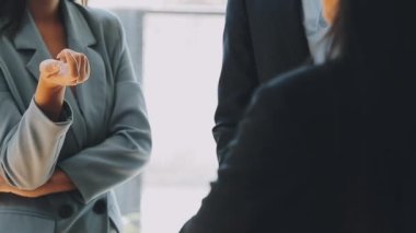 Bir grup sıradan giyinmiş Asyalı iş adamı ofiste fikirleri tartışıyor. Yaratıcı profesyoneller, yeni başarılı girişim projesinin önemli konularını tartışmak üzere toplantıda bir araya geldiler.