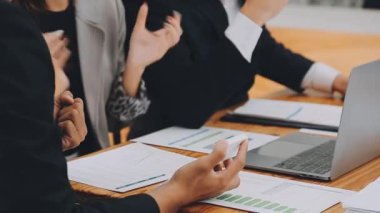 Bir grup sıradan giyinmiş Asyalı iş adamı ofiste fikirleri tartışıyor. Yaratıcı profesyoneller, yeni başarılı girişim projesinin önemli konularını tartışmak üzere toplantıda bir araya geldiler.