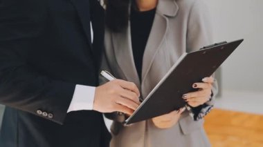 Bir grup sıradan giyinmiş Asyalı iş adamı ofiste fikirleri tartışıyor. Yaratıcı profesyoneller, yeni başarılı girişim projesinin önemli konularını tartışmak üzere toplantı masasında bir araya geldiler.