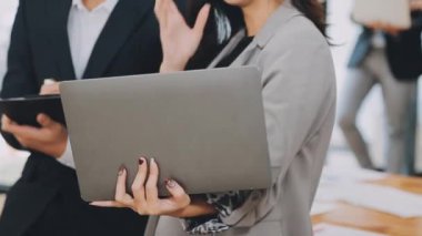 Bir grup sıradan giyinmiş Asyalı iş adamı ofiste fikirleri tartışıyor. Yaratıcı profesyoneller, yeni başarılı girişim projesinin önemli konularını tartışmak üzere toplantı masasında bir araya geldiler.