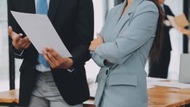 Bir grup sıradan giyinmiş Asyalı iş adamı ofiste fikirleri tartışıyor. Yaratıcı profesyoneller, yeni başarılı girişim projesinin önemli konularını tartışmak üzere toplantı masasında bir araya geldiler.