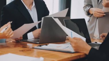 Bir grup sıradan giyinmiş Asyalı iş adamı ofiste fikirleri tartışıyor. Yaratıcı profesyoneller, yeni başarılı girişim projesinin önemli konularını tartışmak üzere toplantı masasında bir araya geldiler.