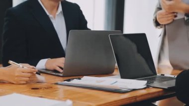 Bir grup sıradan giyinmiş Asyalı iş adamı ofiste fikirleri tartışıyor. Yaratıcı profesyoneller, yeni başarılı girişim projesinin önemli konularını tartışmak üzere toplantı masasında bir araya geldiler.