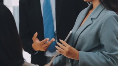 Bir grup sıradan giyinmiş Asyalı iş adamı ofiste fikirleri tartışıyor. Yaratıcı profesyoneller, yeni başarılı girişim projesinin önemli konularını tartışmak üzere toplantı masasında bir araya geldiler.
