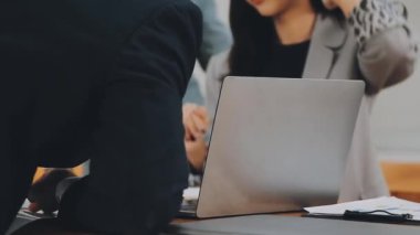 Bir grup sıradan giyinmiş Asyalı iş adamı ofiste fikirleri tartışıyor. Yaratıcı profesyoneller, yeni başarılı girişim projesinin önemli konularını tartışmak üzere toplantı masasında bir araya geldiler.