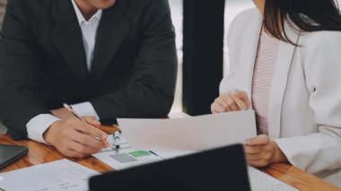 Bir grup sıradan giyinmiş Asyalı iş adamı ofiste fikirleri tartışıyor. Yaratıcı profesyoneller, yeni başarılı girişim projesinin önemli konularını tartışmak üzere toplantı masasında bir araya geldiler.