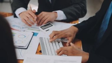 Bir grup sıradan giyinmiş Asyalı iş adamı ofiste fikirleri tartışıyor. Yaratıcı profesyoneller, yeni başarılı girişim projesinin önemli konularını tartışmak üzere toplantı masasında bir araya geldiler.