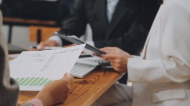 Bir grup sıradan giyinmiş Asyalı iş adamı ofiste fikirleri tartışıyor. Yaratıcı profesyoneller, yeni başarılı girişim projesinin önemli konularını tartışmak üzere toplantı masasında bir araya geldiler.