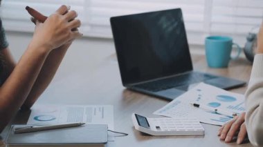 İki genç Asyalı iş kadını yeni başlatılan proje sunumuyla ilgili konuşuyor, tartışıyor, görüşüyorlar. Plan pazarlama ve ofis yatırımlarını analiz ediyorlar..