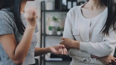 İki genç Asyalı iş kadını yeni başlatılan proje sunumuyla ilgili konuşuyor, tartışıyor, görüşüyorlar. Plan pazarlama ve ofis yatırımlarını analiz ediyorlar..