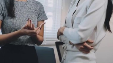 İki genç Asyalı iş kadını yeni başlatılan proje sunumuyla ilgili konuşuyor, tartışıyor, görüşüyorlar. Plan pazarlama ve ofis yatırımlarını analiz ediyorlar..
