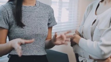 İki genç Asyalı iş kadını yeni başlatılan proje sunumuyla ilgili konuşuyor, tartışıyor, görüşüyorlar. Plan pazarlama ve ofis yatırımlarını analiz ediyorlar..