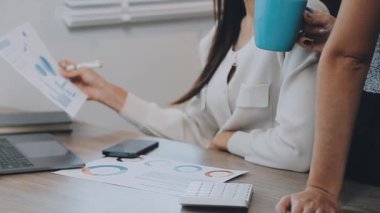 İki genç Asyalı iş kadını yeni başlatılan proje sunumuyla ilgili konuşuyor, tartışıyor, görüşüyorlar. Plan pazarlama ve ofis yatırımlarını analiz ediyorlar..