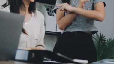 İki genç Asyalı iş kadını yeni başlatılan proje sunumuyla ilgili konuşuyor, tartışıyor, görüşüyorlar. Plan pazarlama ve ofis yatırımlarını analiz ediyorlar..