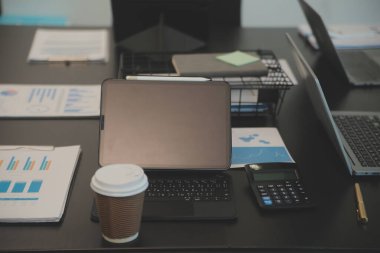 Açık bir finans bürosundaki masada dizüstü bilgisayar..