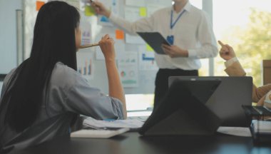 İş ekibi işbirliği mali veriler ve pazarlama büyüme raporlarıyla analiz etmeyi takım halinde, şirket kârından yararlanmak için strateji planlama, sunum ve beyin fırtınası grafiği üzerinde tartışır..