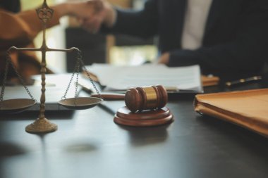 Adalet ve hukuk kavramı. Hukuk Müşaviri tokmak ve yasal hukuk veya yasal ile imzalanmış bir sözleşme istemciye sunar arka planda hukuk firmasında takım toplantısı