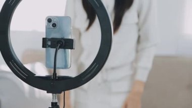 Genç bir kadın kamerada video çekiyor.