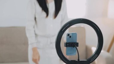 Genç bir kadın kamerada video çekiyor.