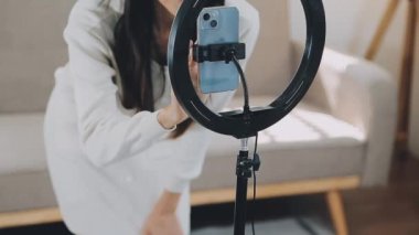 Genç bir kadın kamerada video çekiyor.