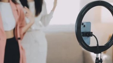 Genç bayan arkadaşlar kameranın önünde video çekiyor.
