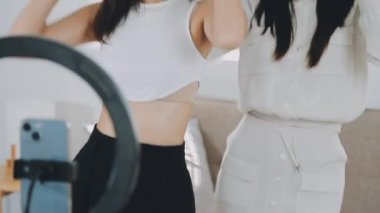 Genç bayan arkadaşlar kameranın önünde video çekiyor.