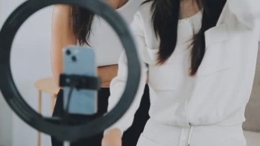 Genç bayan arkadaşlar kameranın önünde video çekiyor.