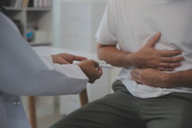 Şiddetli mide ağrısı çeken bir adam evde oturuyor. Karnı ağrıyan, ishal ya da hazımsızlık çeken bir adamın eli. Kafkasyalı adam, acı verici bir şekilde karnına bastırıyor.