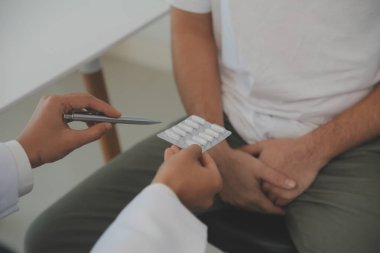 Erkek hastalıkları. Adam ellerini kasıklarına bastırıyor ve acı çekiyor. Panorama, kesilmiş, stüdyo çekimi.