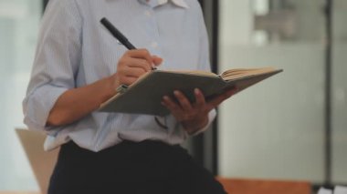 İşletme ve finans dünyasını temsil eden gösterişli bir ofiste çalışan genç bir kadının profesyonel portresi.