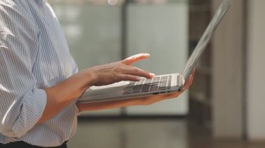 Bilgisayarda çalışan genç iş kadınının portresi modern bir ofis, iş ve finans konsepti arka planında.