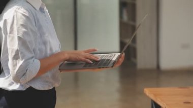 Bilgisayarda çalışan genç iş kadınının portresi modern bir ofis, iş ve finans konsepti arka planında.