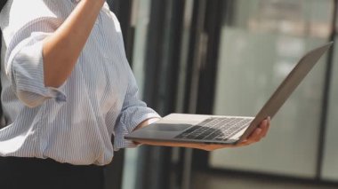 Bilgisayarda çalışan genç iş kadınının portresi modern bir ofis, iş ve finans konsepti arka planında.