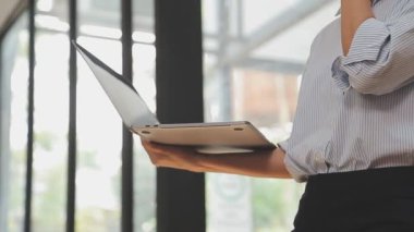 Bilgisayarda çalışan genç iş kadınının portresi modern bir ofis, iş ve finans konsepti arka planında.