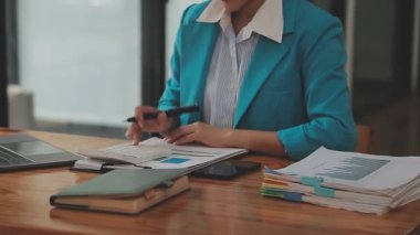 Modern bir ofis içinde görevlerini yapan genç profesyonel bir kadının portresi iş ve finans dünyasının özünü gözler önüne seriyor..