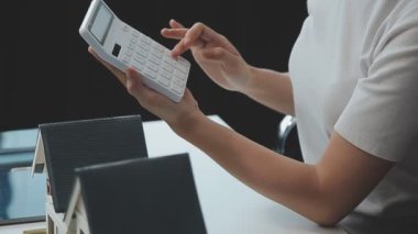 Emlakçı ve müşteriyle ev modeli satın alma, sigorta ya da kredi alma ya da emlak ya da mülkiyet sözleşmesi hakkında tartışıyor.