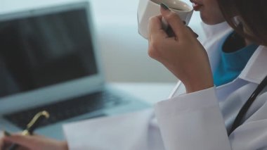 Masada oturan beyaz önlüklü bayan doktor ve steteskop.